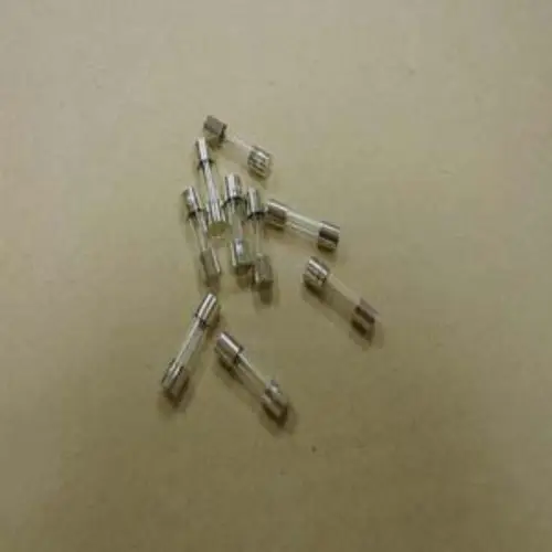 Remeha Feinsicherungen in durchsichtigen Glaskörpern mit metallischen Enden, angeordnet auf einer beige Oberfläche. Ideal für den Einsatz in elektrischen Geräten.